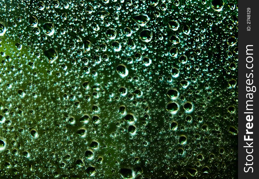 Raindrops over window glass closeup. blurred night background with coloured lights. Raindrops over window glass closeup. blurred night background with coloured lights