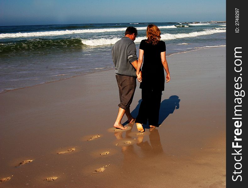 Couple walking on the beach holding hands