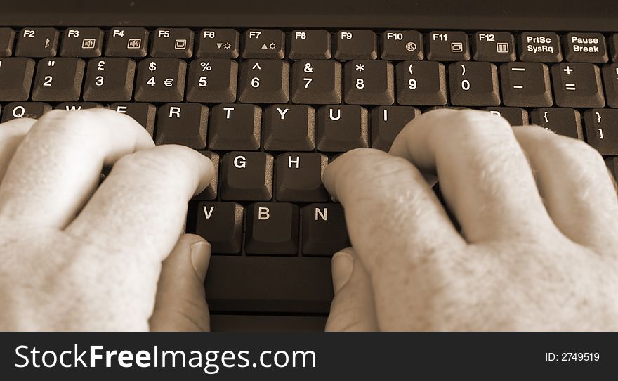 Close-up of Caucasian man's hand on black laptop keyboard. Close-up of Caucasian man's hand on black laptop keyboard