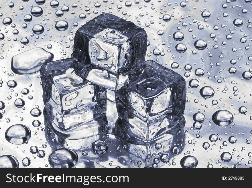 Three pieces of an ice and water drops