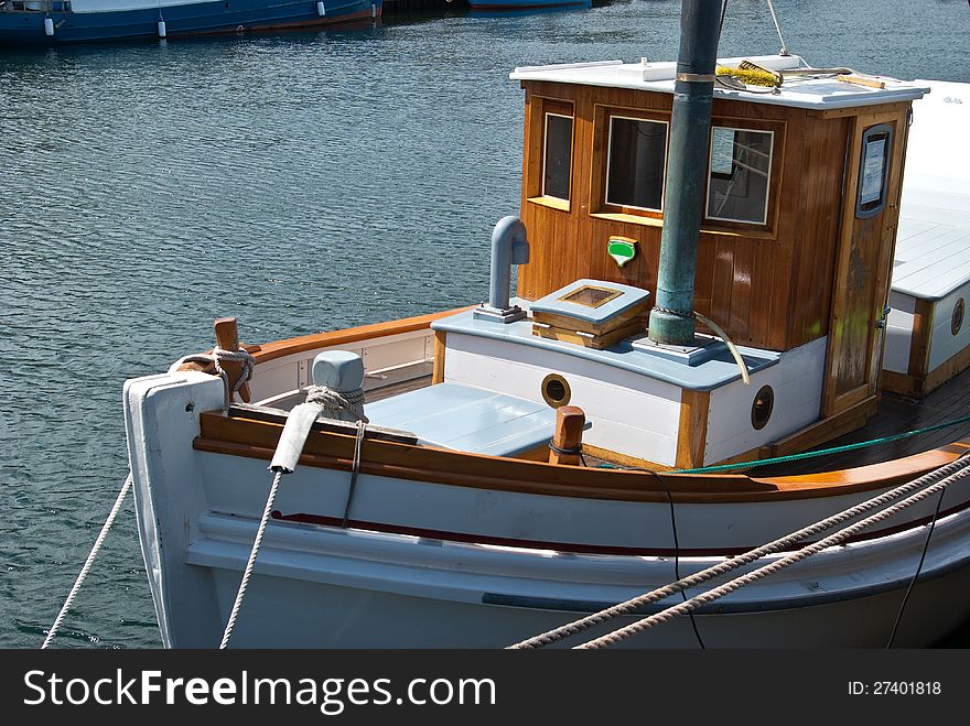 Beautiful classical design wooden sail yacht anchored  in a marina. Beautiful classical design wooden sail yacht anchored  in a marina