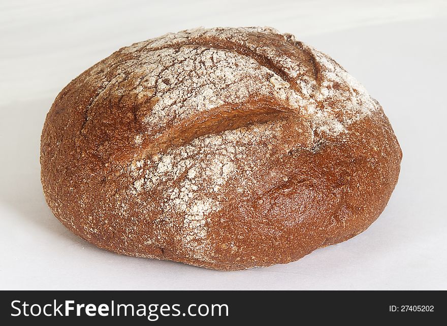 Loaf of round rye bread on white background