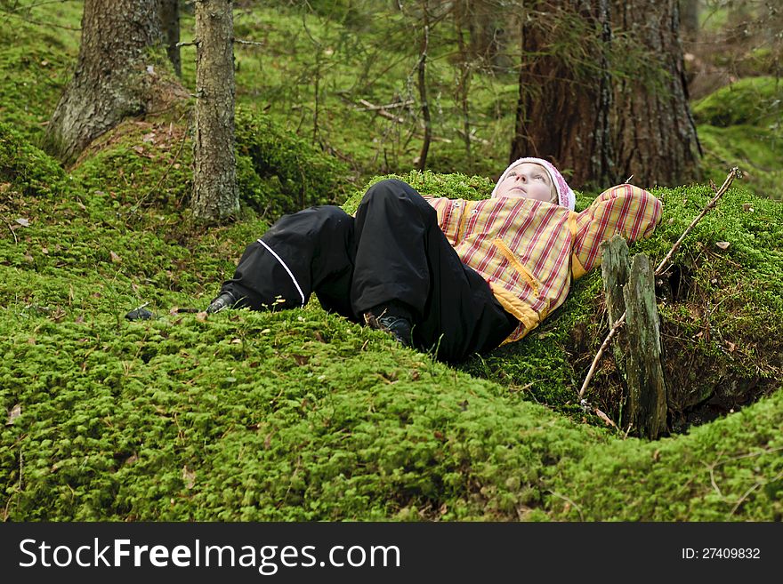 Young girl lying in green moss daydreaming. Young girl lying in green moss daydreaming.