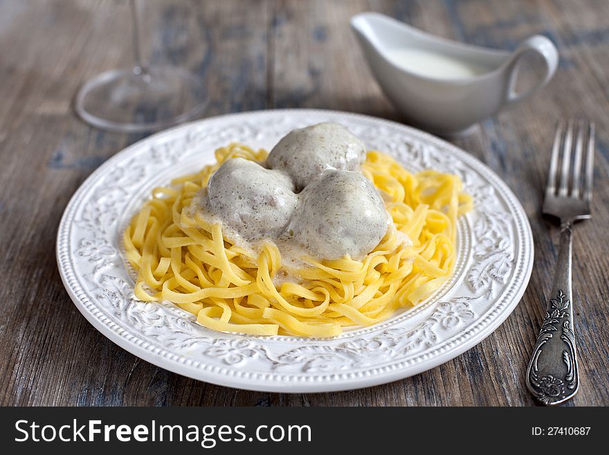 Meatballs with tagliatelli and white sauce in italian style