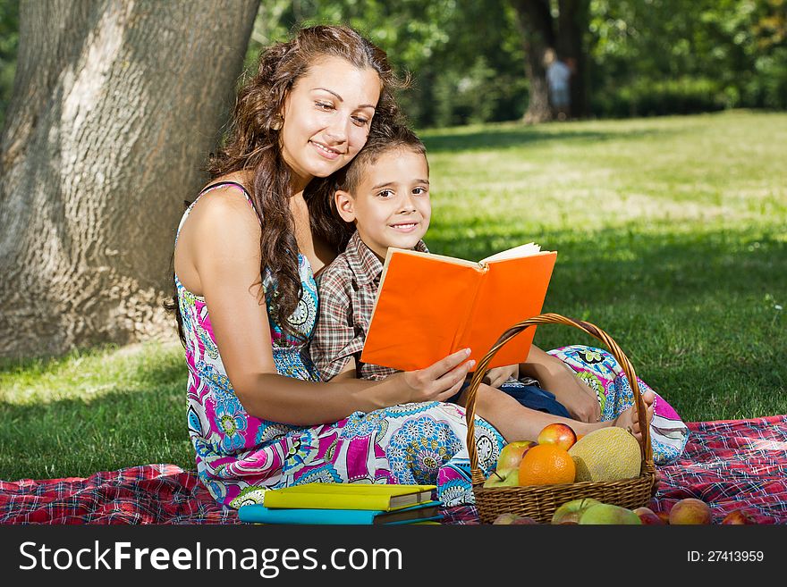 Beautiful mother and little boy reading book together