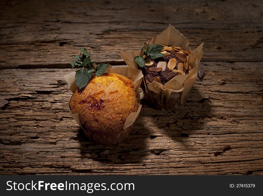 Two muffins with green mint leaves. Two muffins with green mint leaves