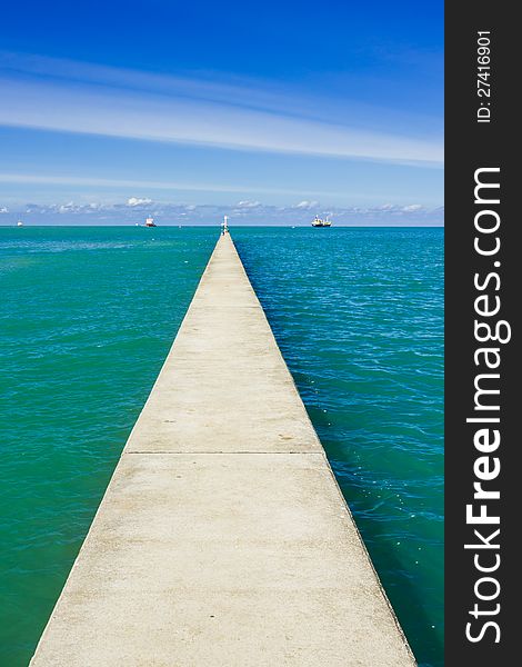 A long and small concrete pier on a sea