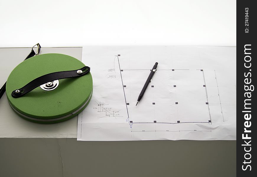 Measuring tape, pencil over a construction drawing