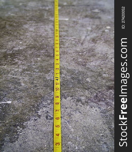 Construction Measuring Tape on Concrete Floor