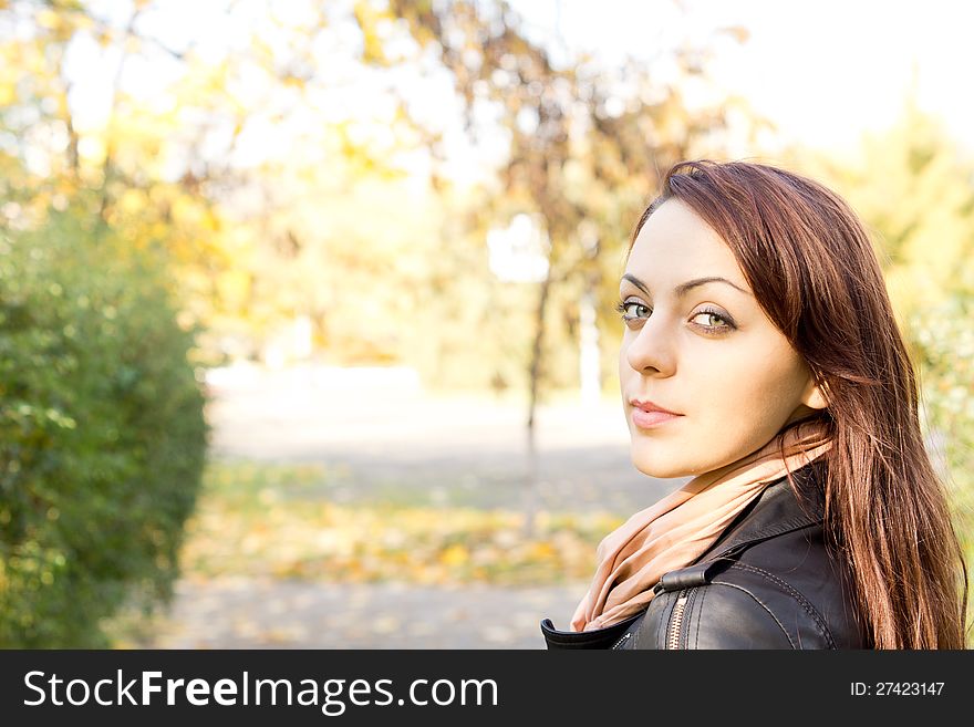 Head and shoulder portrait of a pretty woman with long brunette hair looking back over her shoulder with copyspace. Head and shoulder portrait of a pretty woman with long brunette hair looking back over her shoulder with copyspace