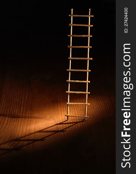 Escape abstract. Wooden ladder with shadow on dark background