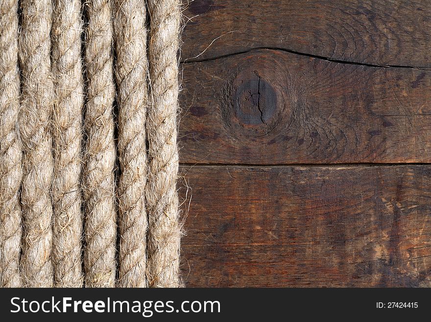 Old hemp rope on dark wooden surface. Old hemp rope on dark wooden surface