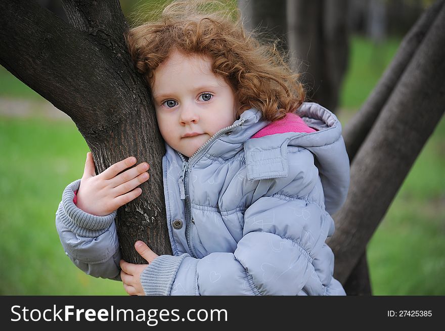 Curly girl on a tree in the park