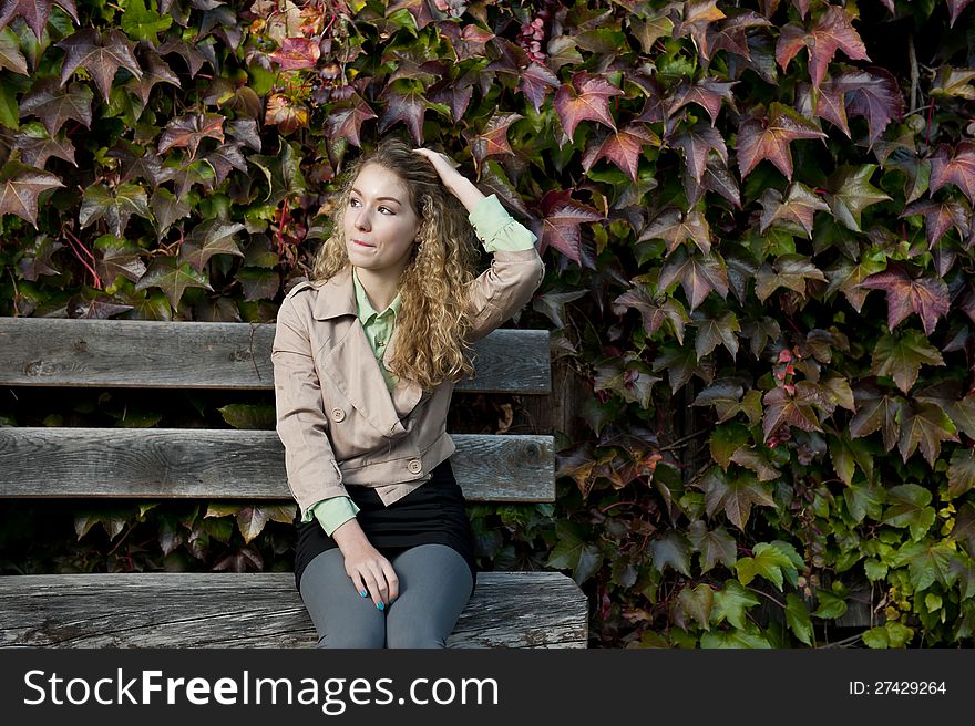 Beautiful teen sitting on a bench in autumn season. Beautiful teen sitting on a bench in autumn season
