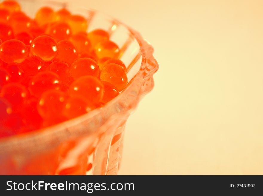 Caviar in the glass on the light brown background. Caviar in the glass on the light brown background