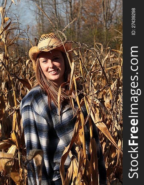 Pretty young girl in the middle of a corn field enjoying a beautiful day in autumn. Pretty young girl in the middle of a corn field enjoying a beautiful day in autumn.