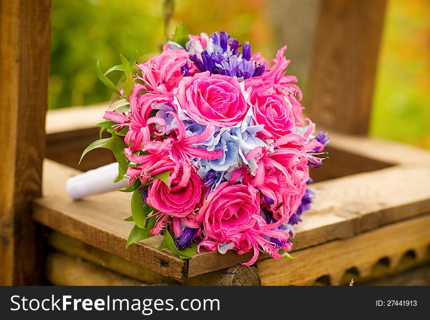 Bride's flower bouquet lying on a wooden well. Bride's flower bouquet lying on a wooden well