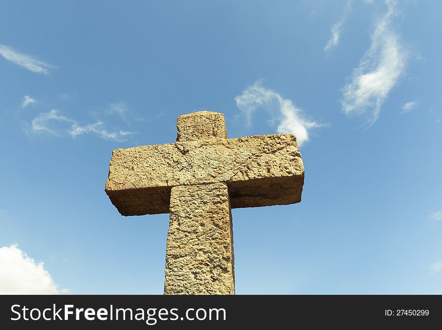 Big detailed stone cross over blue sky background