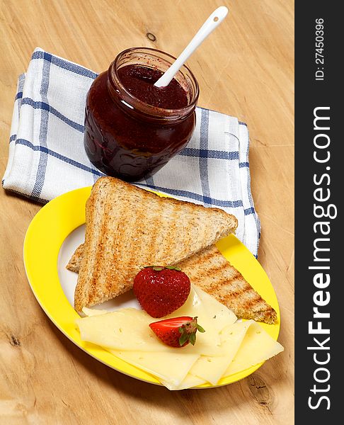 Breakfast Set with Cheese, Strawberries, Jam and Toasts closeup on wooden background