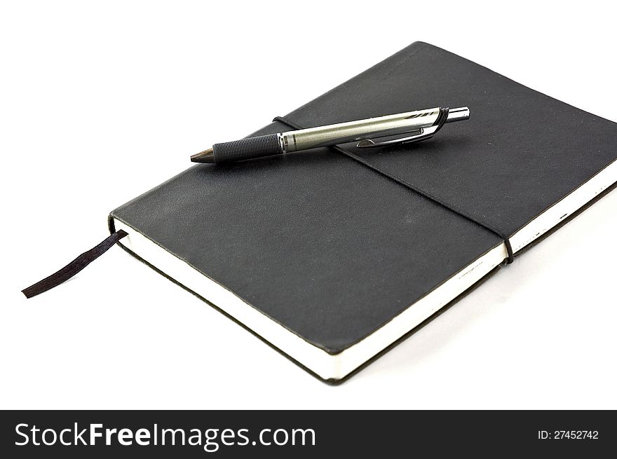 Black notebook with pen on white background