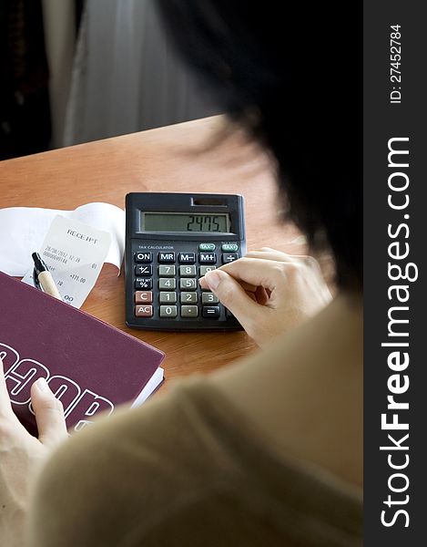 Woman calculating receipts on desk. Woman calculating receipts on desk