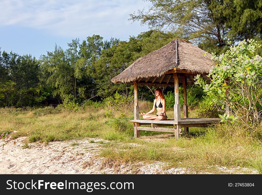 Woman Doing Yoga Meditation In Tropical Gazebo