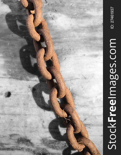 Strong rusty steel chain on the black and white wooden background. Strong rusty steel chain on the black and white wooden background