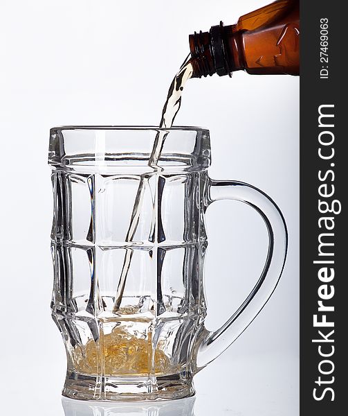 Beer pouring into beer mug isolated