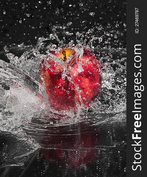 Fresh an apple in streaming splash water on black background. Fresh an apple in streaming splash water on black background