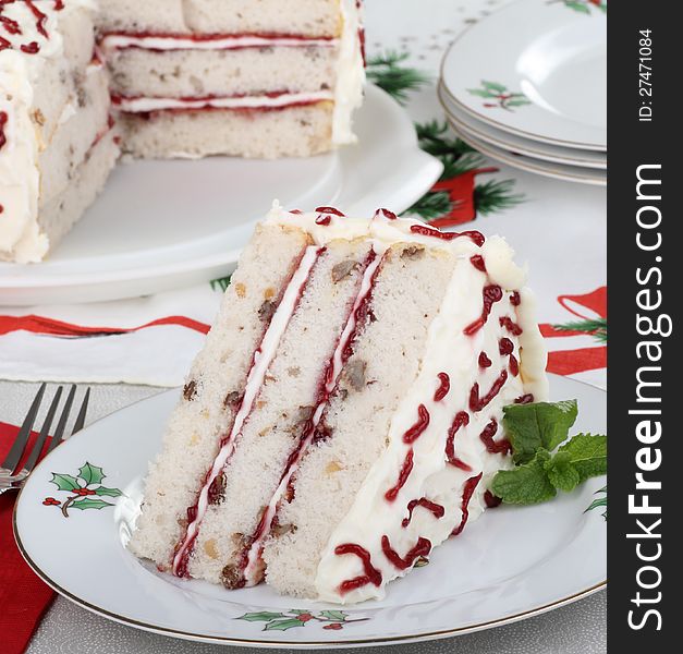 Piece of white layer cake on a Christmas plate. Piece of white layer cake on a Christmas plate