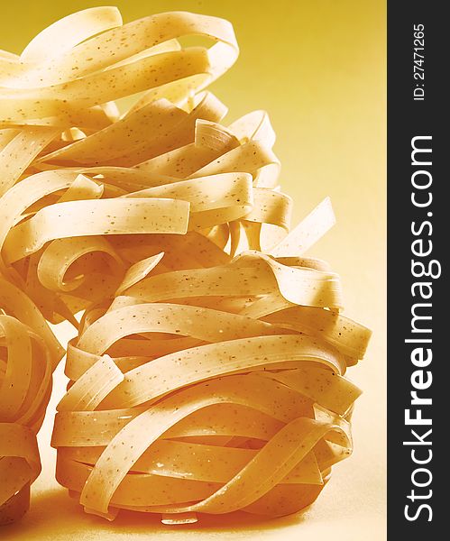 Italian pasta fettuccine on yellow gradient surface