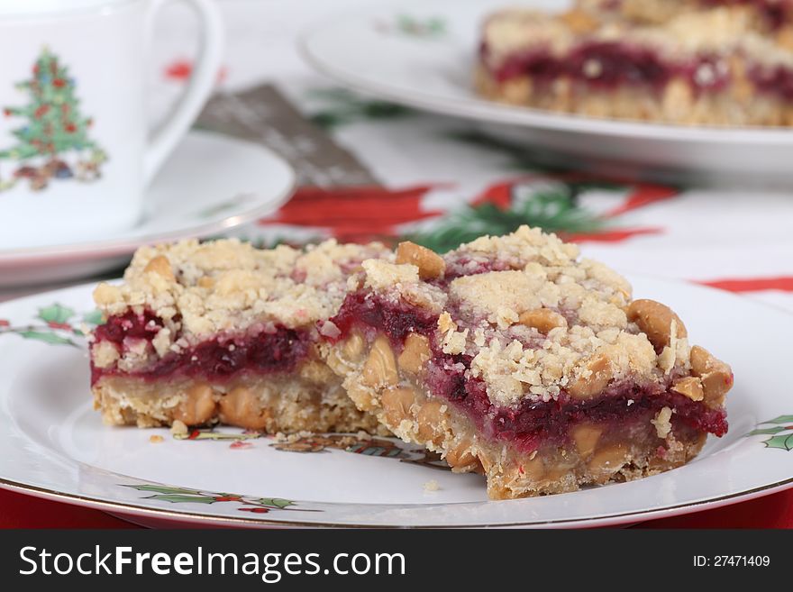 Two cranberry bars with peanut butter chips on a Christmas plate. Two cranberry bars with peanut butter chips on a Christmas plate