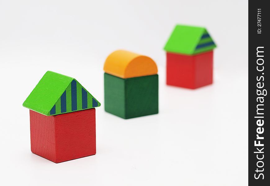 Three toy houses made of wooden blocks
