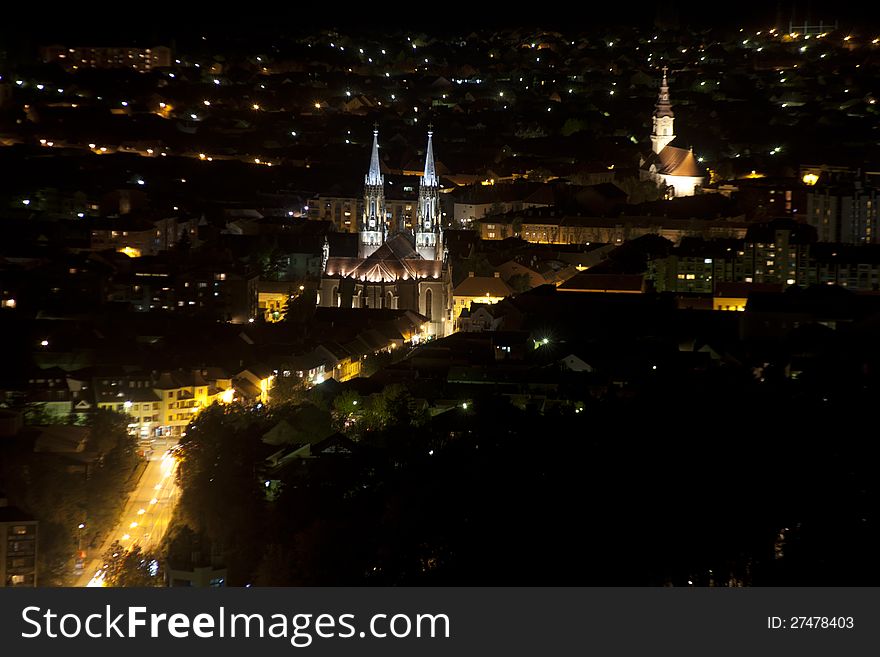 City panorama at night with two churches