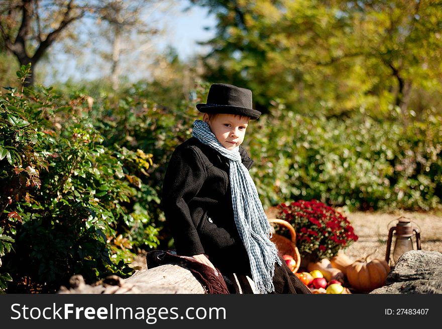 Boy in a black coat and hat at the picnic. Boy in a black coat and hat at the picnic