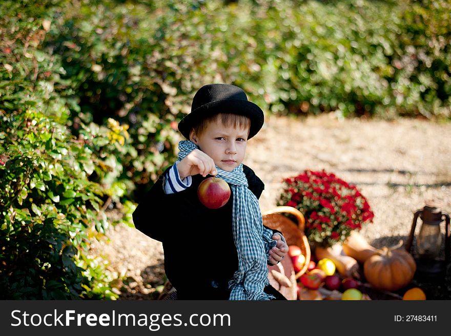 Boy in a black coat and hat at the picnic. Boy in a black coat and hat at the picnic