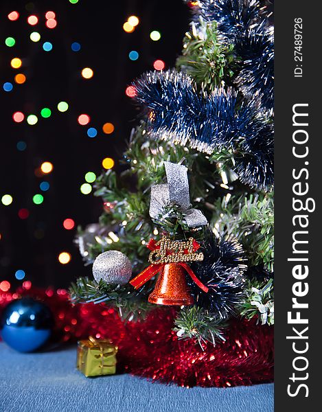 Decorated Christmas tree,the Christmas bell on a black background with bright lights. Decorated Christmas tree,the Christmas bell on a black background with bright lights