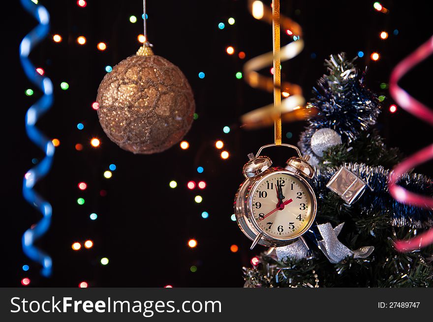 Christmas ball,clock,serpentine,a decorated Christmas tree on a black background with lights. Christmas ball,clock,serpentine,a decorated Christmas tree on a black background with lights