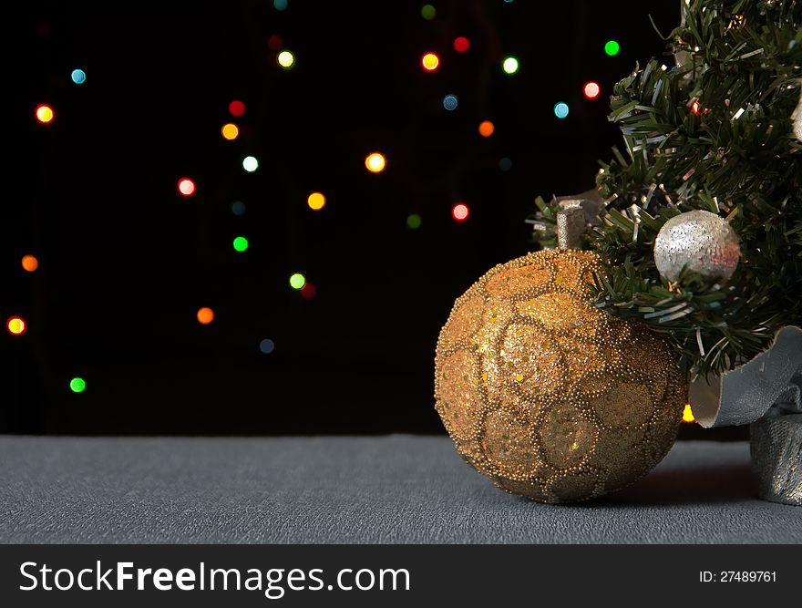 Golden ball under a decorated Christmas tree