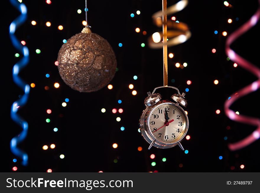 Clock,serpentine,Christmas ball on a black background with lights