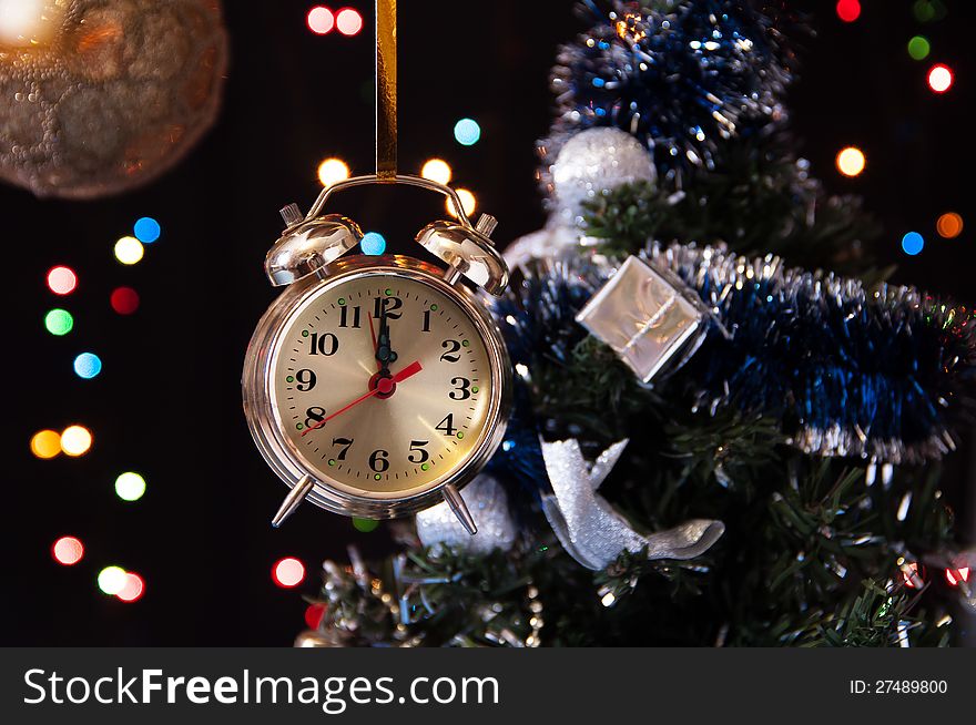 Clock ,a decorated Christmas tree on a black background with lights