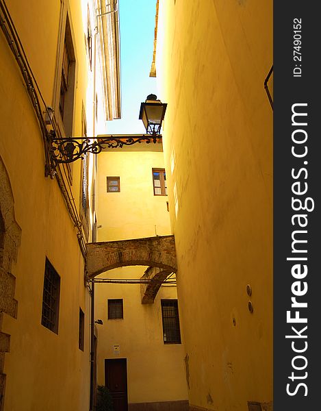 Pistoia, Tuscany,Italy.Foto presents a well-preserved and charming medieval city with typical narrow streets.Blue sky, yellow walls with windows and lantern. Pistoia, Tuscany,Italy.Foto presents a well-preserved and charming medieval city with typical narrow streets.Blue sky, yellow walls with windows and lantern.