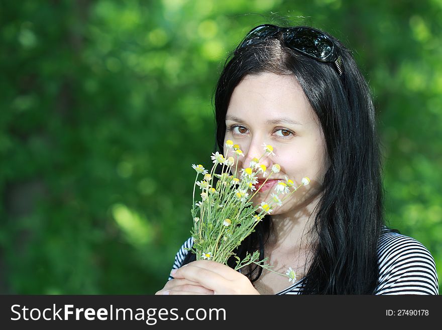 Brunette Smelling Flowers