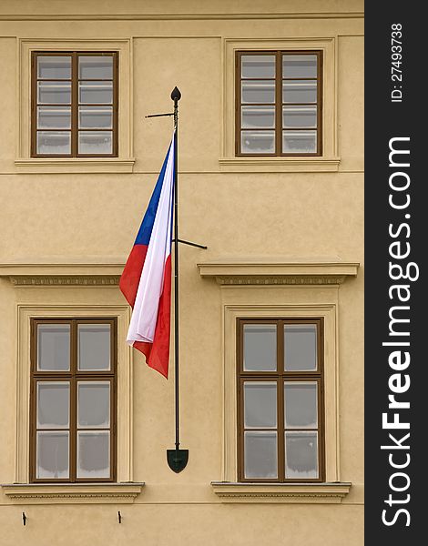 Czech flag hanging on the facade of the house between four windows