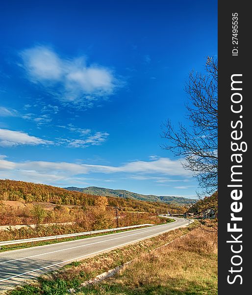 Empty curved road,blue sky and sun.