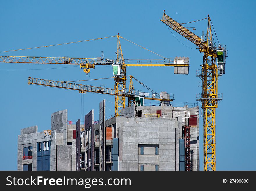 Buildings under construction with yellow cranes. Buildings under construction with yellow cranes