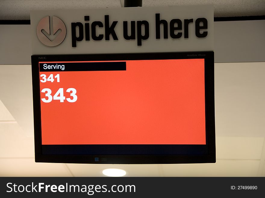 A pick up sign with screen displaying serving numbers