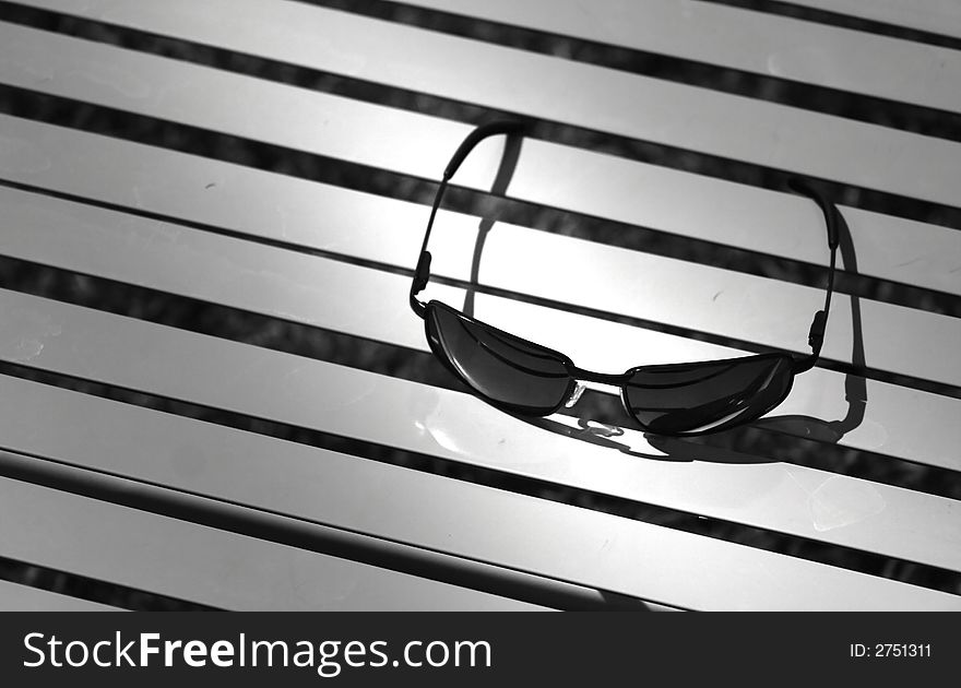 Sun glasses on beach chair concept in black and white