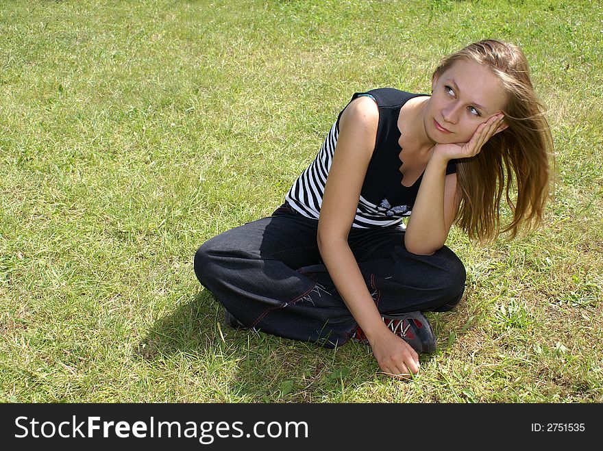 The girl sits on a grass. The girl sits on a grass