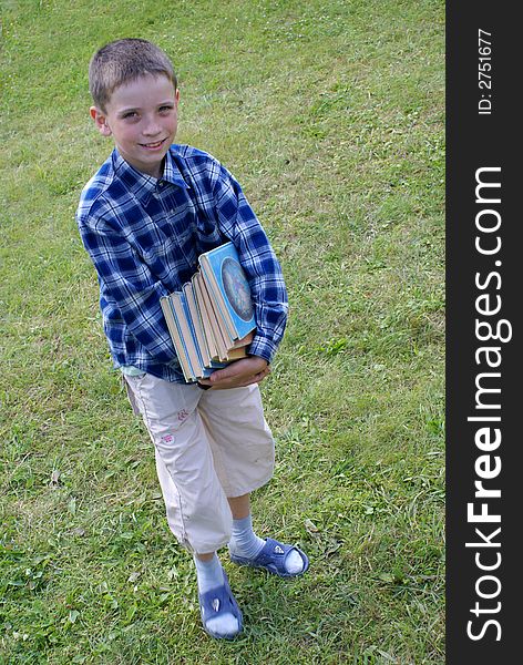 The boy drags a pile of heavy books. The boy drags a pile of heavy books